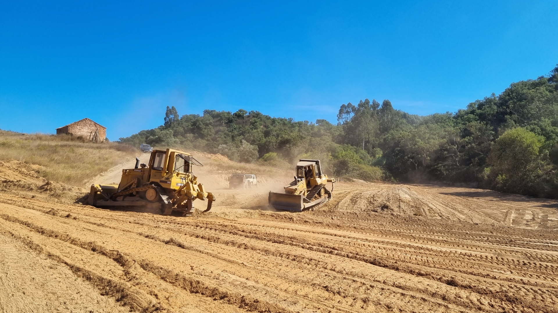 Earthworks begin, shaping the valley for water retention.