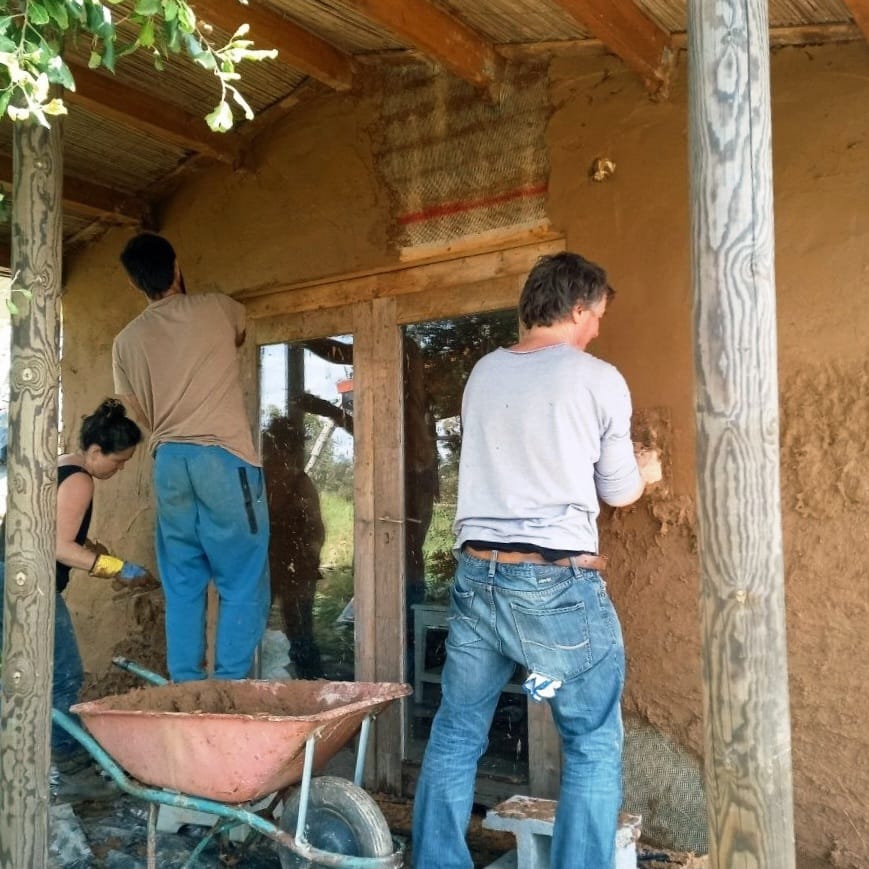 Applying natural clay plaster to an exterior wall at Mosaic