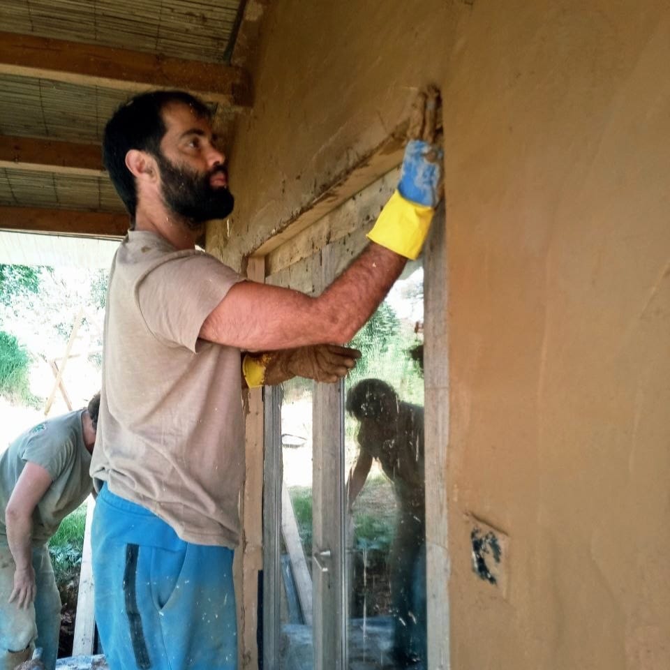 Smoothing a finish coat of clay plaster around a doorway