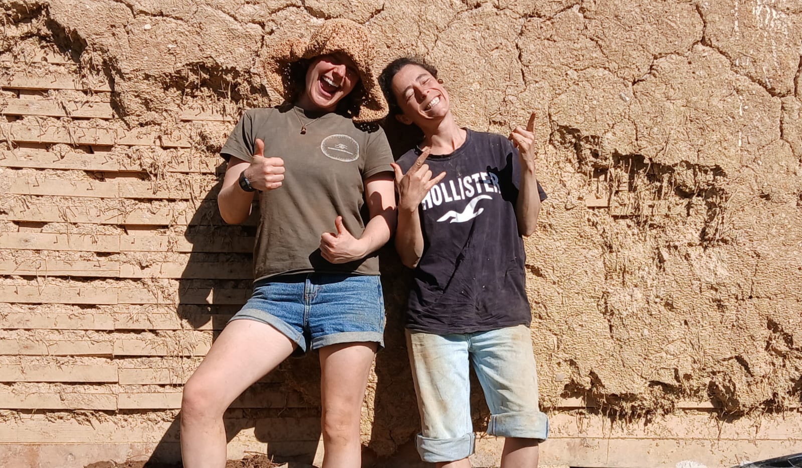 Two participants in front of a freshly plastered wall